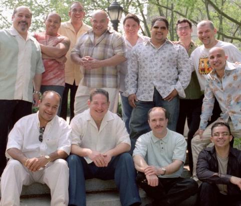 Oscar Hernández (sitting 3rd from the left) is the founder, director and pianist from the Spanish Harlem Orchestra and was the arranger and producer of The Capeman.